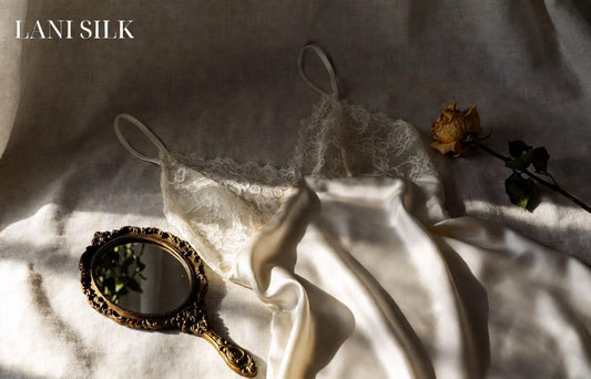 Vintage ivory silk nightgown with lace trim displayed on cream linen background